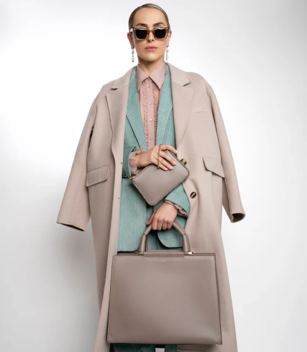 Model wearing two SEYER bags in light pastel colors showcasing luxury leather accessories