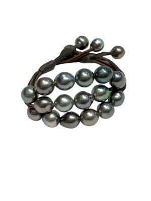 Bracelet with three rows of semi-baroque Tahitian pearls mounted on rolled leather, adjustable clasp for 15–18 cm wrists.