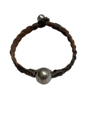 Braided leather bracelet featuring a round Tahitian pearl centerpiece and adjustable pearl clasp.