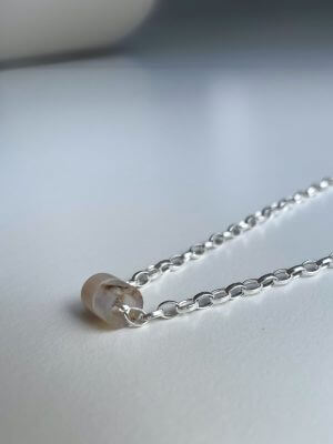 „Delicate sterling silver necklace, 44 cm length, intuitively adjustable, with two crystal donut pendants in pink jade and chalcedony; handcrafted from recycled materials, symbolizing love, harmony, openness, and emotional balance.“