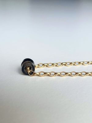„Timeless 18K gold-plated sterling silver necklace, 48 cm length, adjustable to 46 cm and 44 cm, with two crystal donut pendants in onyx and smoky quartz; handcrafted from recycled materials, symbolizing grounding, clarity, and transformation.“