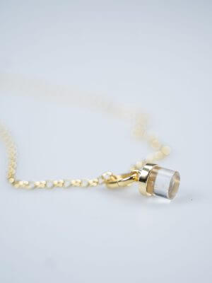 Close-up of a gold-plated sterling silver necklace with a single elegant chain, featuring a golden clear quartz charm and a refined clip for interchangeable crystal charms.