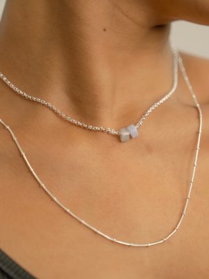 „Timeless 925 sterling silver necklace, 48 cm length, adjustable to 46 cm and 44 cm, with two crystal donut pendants in aquamarine and chalcedony; handcrafted from recycled materials, symbolizing calm, courage, openness, and emotional balance.“